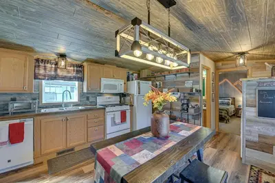 a kitchen with a table with a vase of flowers on it at Northville Cabin with Fire Pit, 4 Mi to Boat Ramp! in Northville