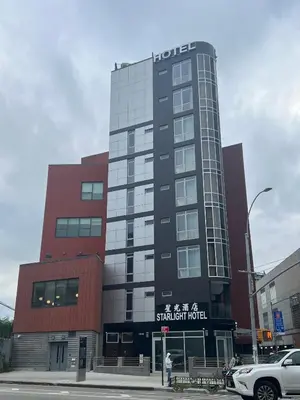 a tall building with a sign on the front of it at Starlight Hotel Near LGA Airport in Queens