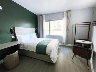 a bedroom with a bed with a green wall at Starlight Hotel Near LGA Airport in Queens