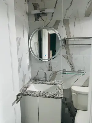 a white bathroom with a sink and a mirror at Starlight Hotel Near LGA Airport in Queens