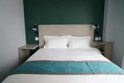 a bedroom with a large bed with a green wall at Starlight Hotel Near LGA Airport in Queens