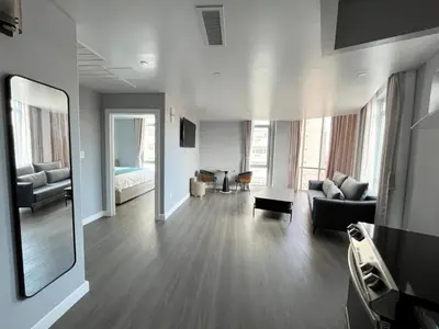 a living room with a couch and a mirror at Starlight Hotel Near LGA Airport in Queens