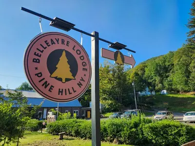 a sign for a welcome to wine hill inn at Belleayre Lodge in Pine Hill