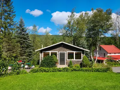 a house in the middle of a green yard at Belleayre Lodge in Pine Hill