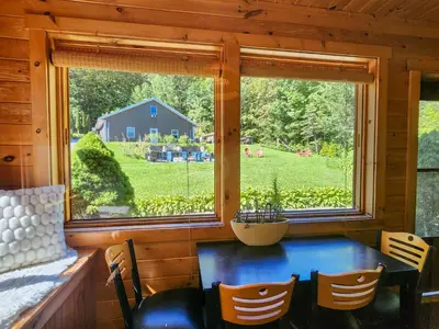 a dining room with a table and a large window at Belleayre Lodge in Pine Hill