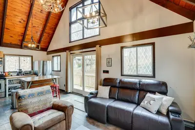 a living room with a leather couch and a table at Hunter Mountain Home with Game Room 1 Mi to Skiing! in Hunter