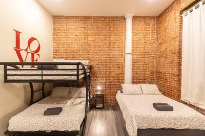 a room with two bunk beds and a brick wall at STUDIOPLUS by JGSTAY, Midtown ESB in New York