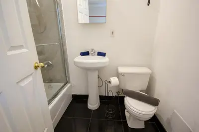 a white bathroom with a toilet and a sink at STUDIOPLUS by JGSTAY, Midtown ESB in New York