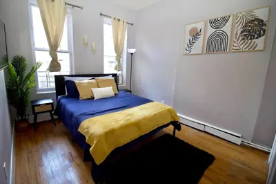 a bedroom with a bed with a blue blanket at Tuk Ahoy - Indigo Suite (3A) with Shared Spaces in Brooklyn