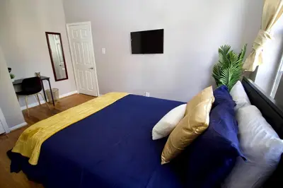 a bedroom with a blue bed with pillows at Tuk Ahoy - Indigo Suite (3A) with Shared Spaces in Brooklyn