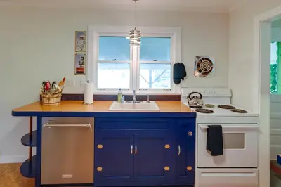 a kitchen with blue cabinets and a sink and a stove at Windham Home Near Mountain Biking and Hiking Trails! in Windham