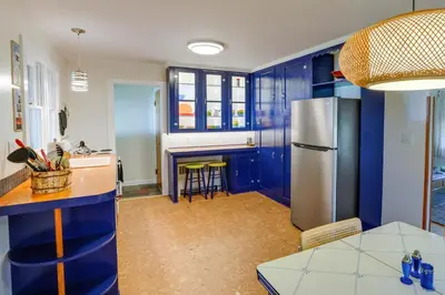 a kitchen with blue cabinets and a stainless steel refrigerator at Windham Home Near Mountain Biking and Hiking Trails! in Windham