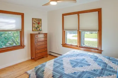 a bedroom with two windows and a bed and a dresser at Windham Home Near Mountain Biking and Hiking Trails! in Windham