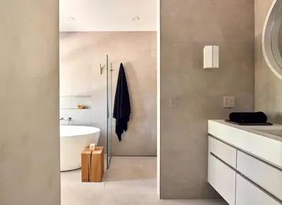 two images of a bathroom with a sink and a tub at 9 Academy in Salisbury