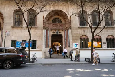 a group of people standing outside of a building at West Side YMCA in New York