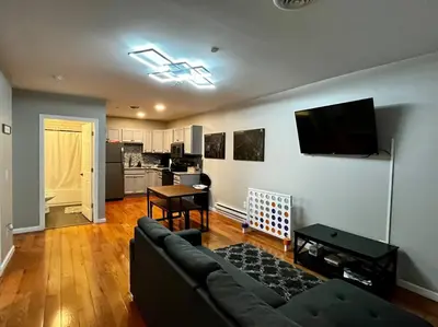 a living room with a couch and a kitchen at Downtown Albany 2 Bedroom + Workstation @ The Mark in Albany
