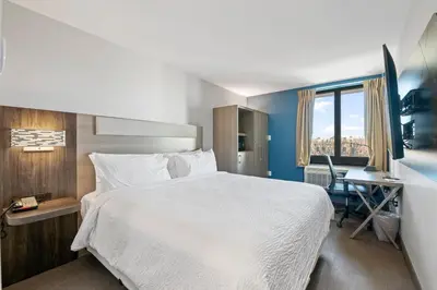 a hotel room with a large bed and a desk at Holiday Inn Express & Suites Bronx - Zoo Area by IHG in Bronx