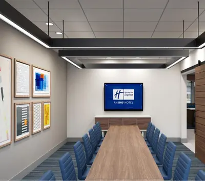 a conference room with a tv and blue chairs at Holiday Inn Express & Suites Bronx - Zoo Area by IHG in Bronx