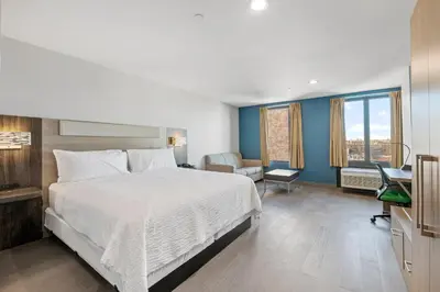 a bedroom with a bed and a desk and a chair at Holiday Inn Express & Suites Bronx - Zoo Area by IHG in Bronx