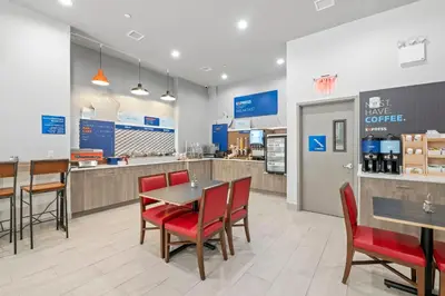 a restaurant with a table and chairs and a counter at Holiday Inn Express & Suites Bronx - Zoo Area by IHG in Bronx
