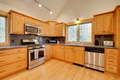 a kitchen with wooden cabinets and stainless steel appliances at West Dover Family Home with Game Room and Home Theater in West Dover