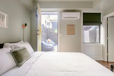 a bedroom with a large white bed and a window at Airy Greenwich Retreat with Private Deck in New York