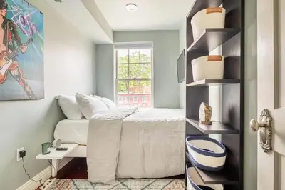 a small bedroom with a bed and a window at Lofty & Bright Greenwich Getaway w Private Rooftop in New York