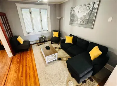 a living room with a black couch and yellow pillows at Cozy Home close to New York City in Fairview