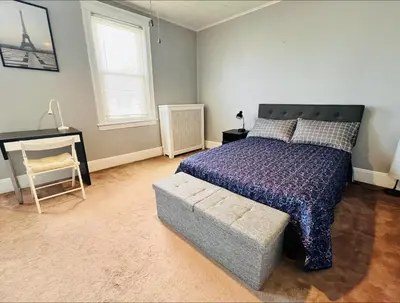 a bedroom with a bed and a chair and a desk at Cozy Home close to New York City in Fairview