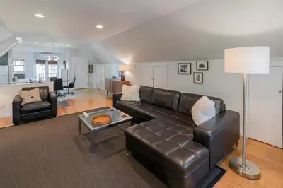 a living room with a leather couch and a table at The Carriage House Loft in Kingston