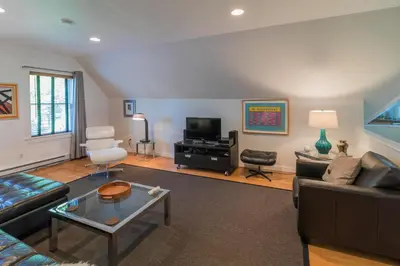 a living room with a couch and a table at The Carriage House Loft in Kingston