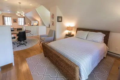 a bedroom with a bed and a desk and a chair at The Carriage House Loft in Kingston
