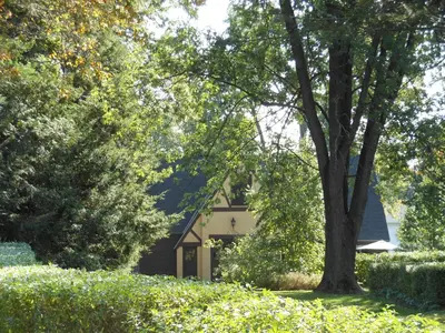 a house with a tree in the middle of a yard at The Carriage House Loft in Kingston