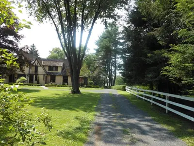 a house with a tree in the middle of a road at The Carriage House Loft in Kingston