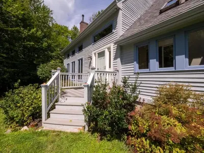 a white house with a white porch and stairs at Berkshire Vacation Rentals: Pristine Home In Becket Woods in Becket
