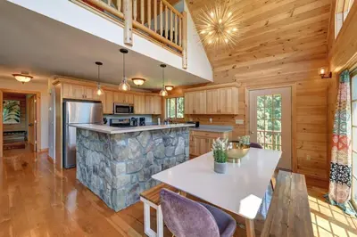 a kitchen with a stone counter and a table and chairs at Berkshire Vacation Rentals: Great Barrington Cabin Sleeps 14 Walk To Town in Great Barrington