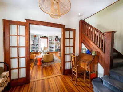 a living room with a staircase and a desk at Classic Stockbridge Cottage in Stockbridge