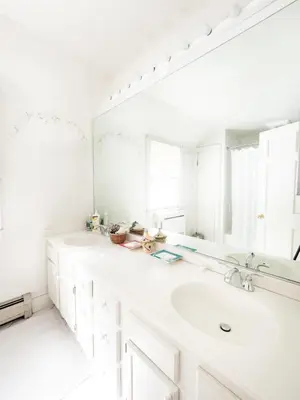 a white bathroom with a sink and a mirror at Classic Stockbridge Cottage in Stockbridge