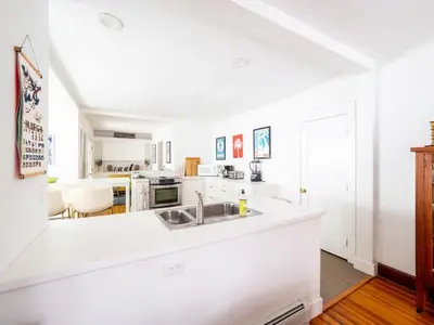 a white kitchen with a sink and a counter at Classic Stockbridge Cottage in Stockbridge
