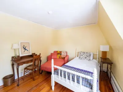 a bedroom with a bed and a desk and a chair at Classic Stockbridge Cottage in Stockbridge