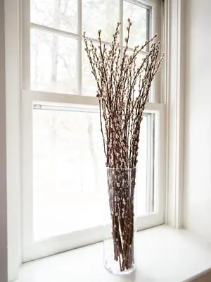 a vase filled with sticks sitting on a window sill at Classic Stockbridge Cottage in Stockbridge