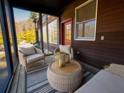 a porch with a table and chairs on a house at Private Berkshires Home On 5+ Acres Rustic & Chic in Otis