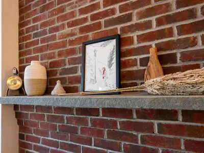 a brick wall with a framed picture on a shelf at Private Berkshires Home On 5+ Acres Rustic & Chic in Otis