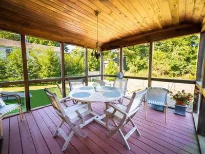 a patio with a table and chairs on a wooden deck at Berkshire Vacation Rental: Stockbridge Home Come Experience The Berkshires in Stockbridge