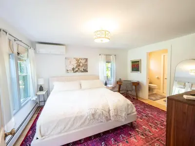 a bedroom with a white bed and a red rug at Berkshire Vacation Rental: Stockbridge Home Come Experience The Berkshires in Stockbridge