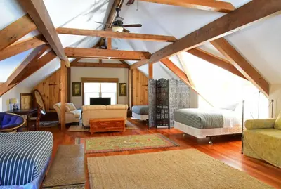 a living room with a vaulted ceiling with wooden beams at Berkshire Vacation Rentals: Peaceful Post and Beam Loft Sleeps 9 in New Marlborough