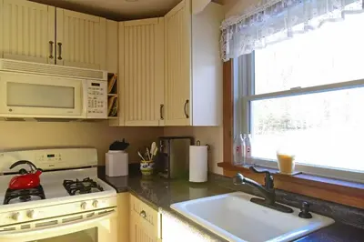 a kitchen with a sink and a stove and a microwave at Berkshire Vacation Rentals: Peaceful Post and Beam Loft Sleeps 9 in New Marlborough