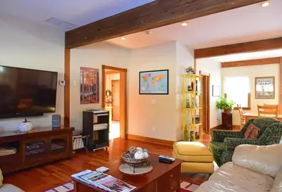 a living room with a couch and a flat screen tv at Berkshire Vacation Rentals: Peaceful Post and Beam Loft Sleeps 9 in New Marlborough