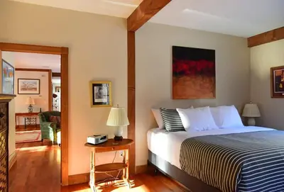 a bedroom with a bed and a table with a lamp at Berkshire Vacation Rentals: Peaceful Post and Beam Loft Sleeps 9 in New Marlborough