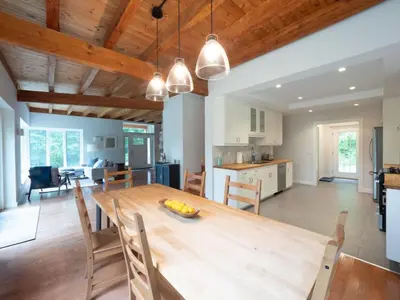 a kitchen and living room with a wooden table and chairs at Berkshire Vacation Rentals: High End Berkshires Getaway in East Hillsdale